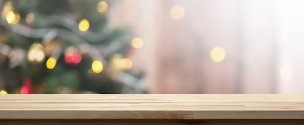 Wood table top on colorful bokeh background from decorated Christmas tree