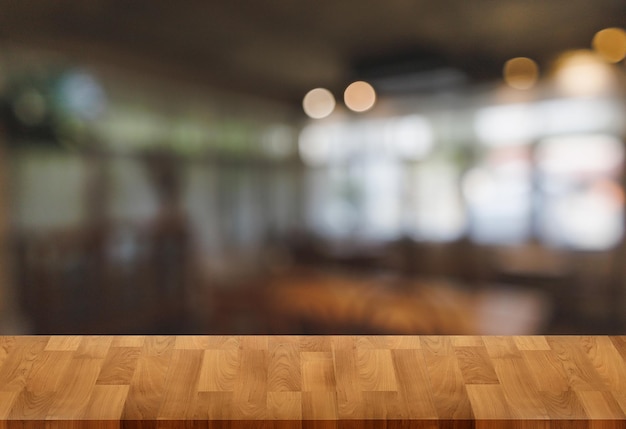 Wood table with blur in coffee shop cafe For montage product display table copy space cafe background with copy space for text