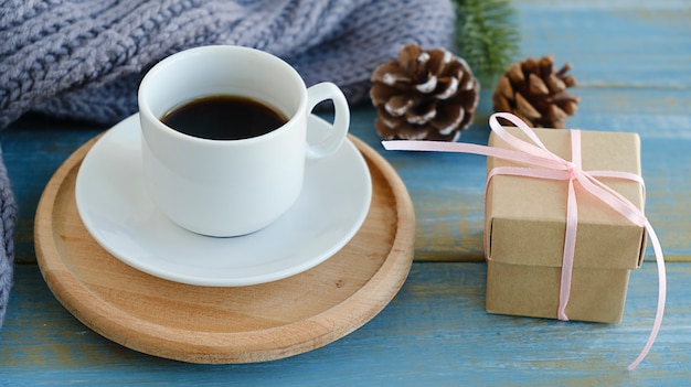 Wood table with cup of latte coffee and Christmas decoration with gift box. Christmas and new year celebration concept.