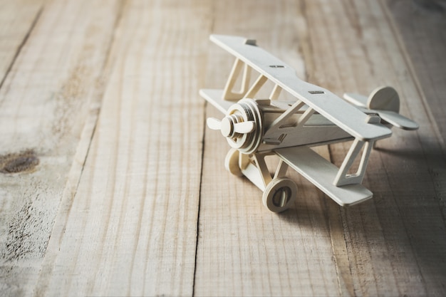 Wood toy airplane on wood table view from above.