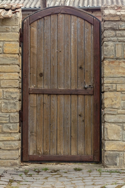 Wooden antique door in a stone wall. Place for an inscription. Copy Space