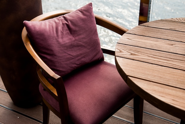 Wooden armchair. Wooden armchair near the table. Burgundy color