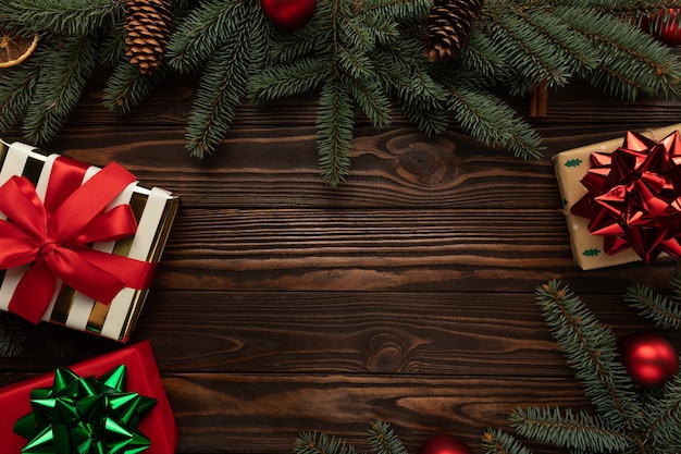 Wooden background decorated with Christmas decorations and gifts.