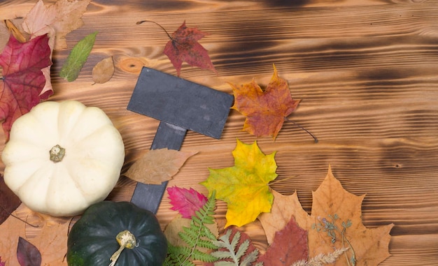 Wooden background, dry autumn leaves and pumpkins