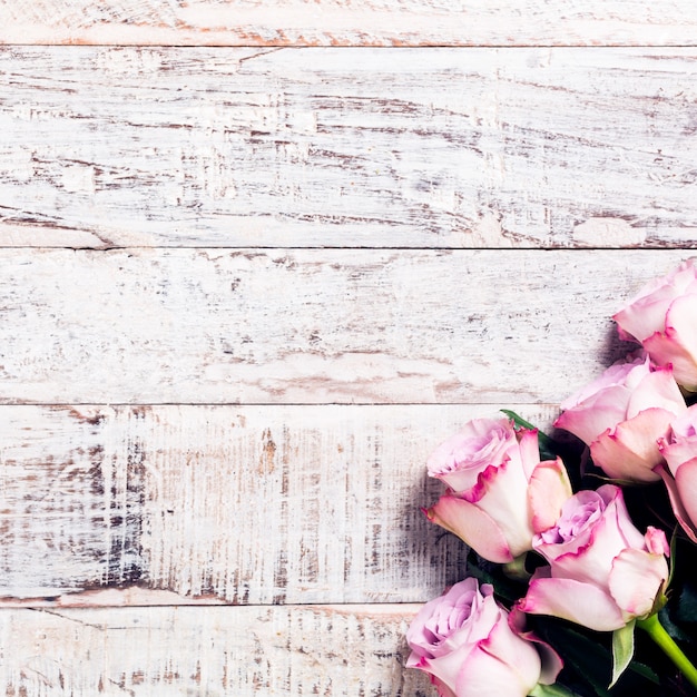 Wooden background with bouquet of pink roses