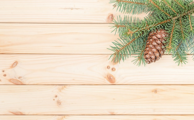 Photo wooden background with cone and twig of spruce