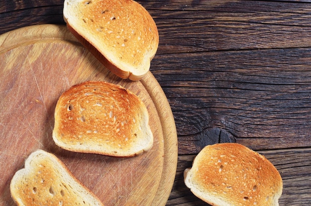 Wooden background with toast bread, top view