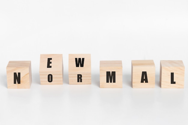 Wooden block cubes flipping new normal wording. New normal after coronavirus pandemic with social distancing, good hygiene. on white background.