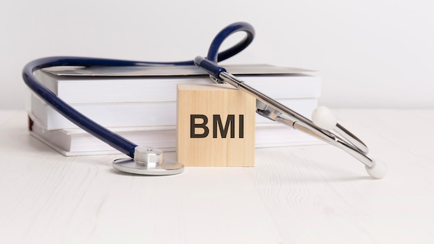 Wooden block form the text BMI body mass index with stethoscope notepad medical concept