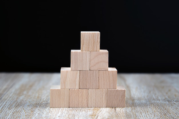 Photo wooden block toy stacked in pyramid shape without graphics.