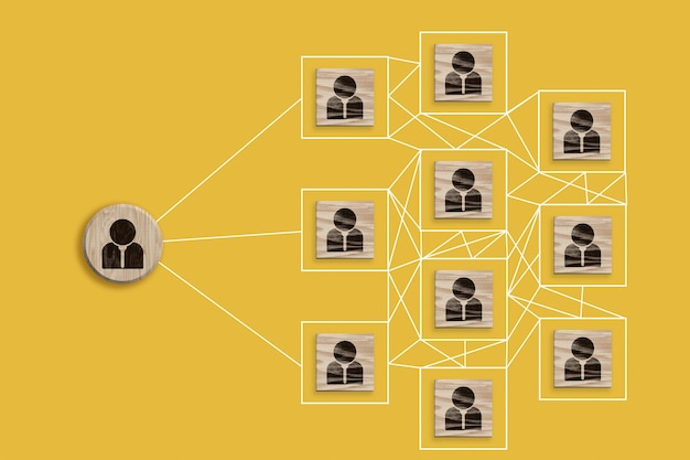 Wooden block with staff icon which link connection network for organisation structure social network and teamwork concept top view