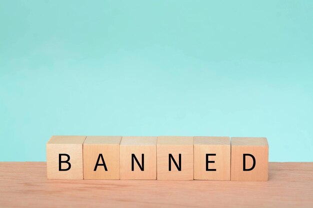 Wooden block with text BANNED A ban refers to a formal or official prohibition or restriction on a particular activity action item or person It is an authoritative decision made by a government