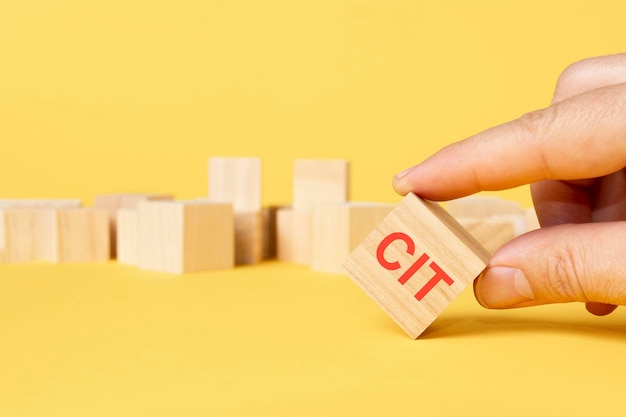 Wooden block with text CIT on yellow background