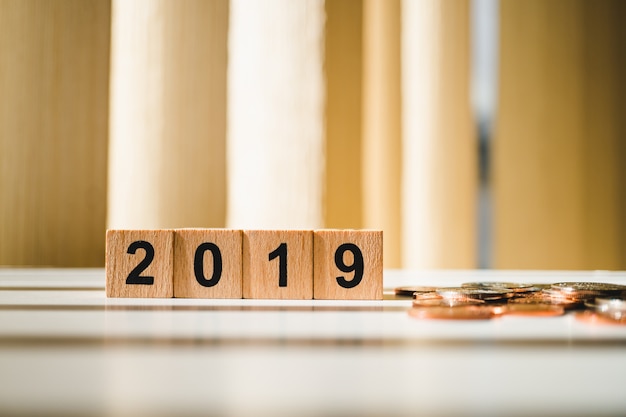 Wooden block year 2019 with stack coins using as business and finance concept