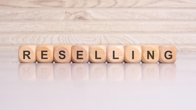 Photo wooden blocks spelling reselling on a gray background