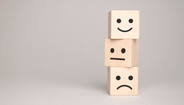 Wooden blocks with the happy face smile face symbol symbol on the table, evaluation,