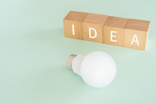 Photo wooden blocks with idea text of concept and a lightbulb.