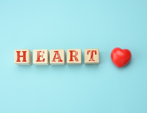 Wooden blocks with the inscription Heart on a blue surface