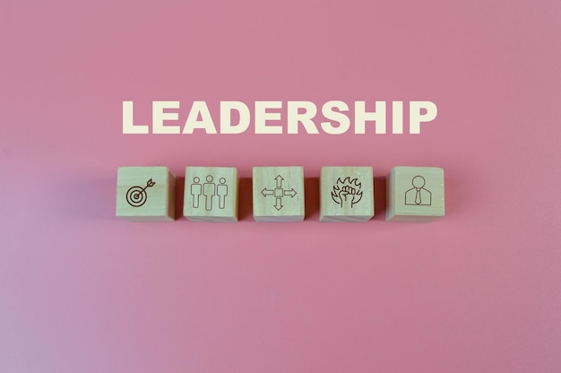 Photo wooden blocks with leadership symbols business concept