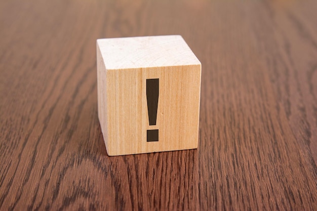 Wooden blocks with question marks on wooden table close up space for text