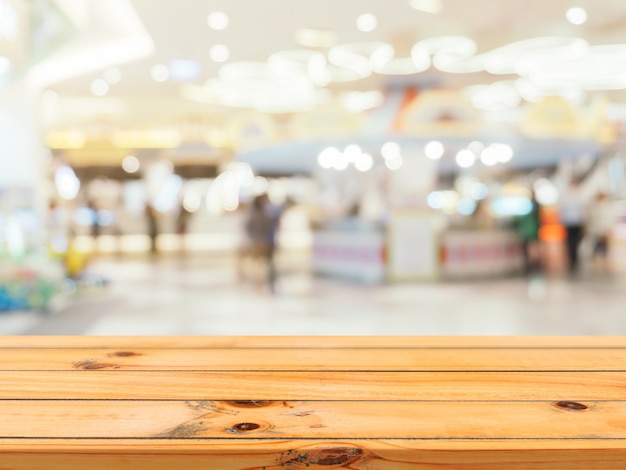 Wooden board empty table blur in department store background.