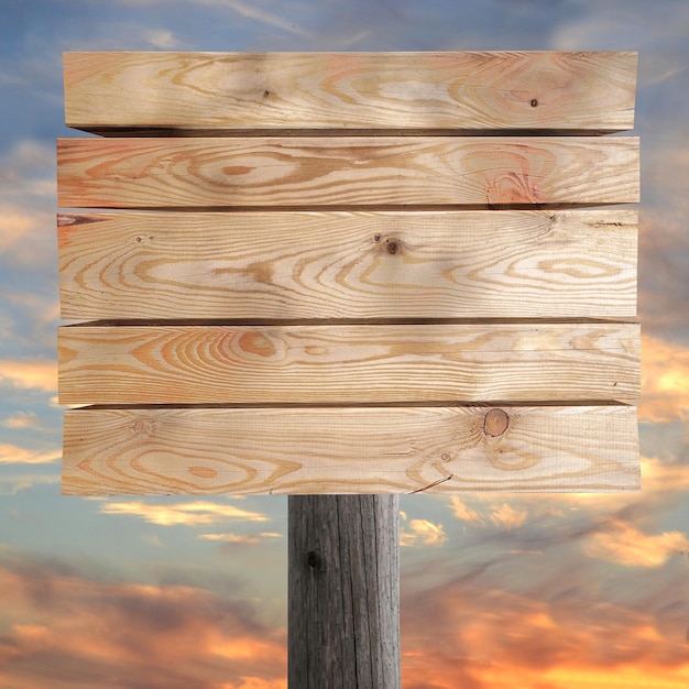 Wooden board on post with sunset sky in background