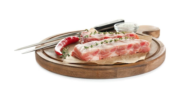 Wooden board with fresh raw ribs on white background