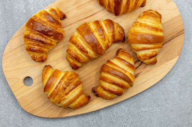 Wooden board with freshly baked croissants