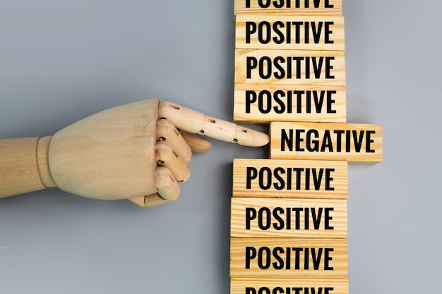 wooden board with positive and negative words. hands reject negative words. the concept of choosing