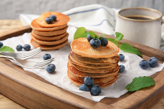 Wooden board with tasty buckwheat pancakes