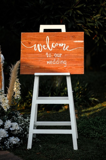 Photo wooden board with text welcome wedding ceremony decoration in garden