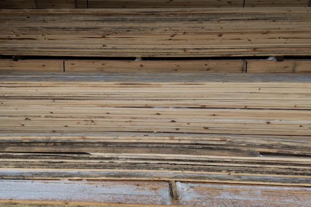 Wooden boards storage under a canopy with snow and metled ice on the floor