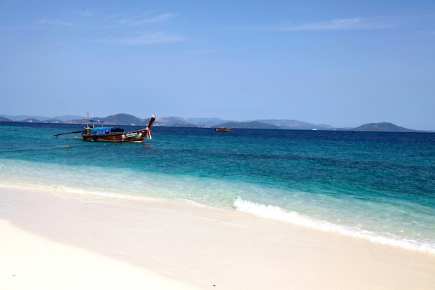 Wooden boat on the beach at sunny day in summer with blue sea. Summer activities concept.