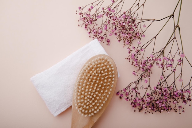 Wooden body massage brush on a pink backgorund Scin care concept