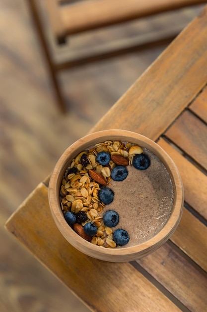 Wooden bowl of flaxseed or linen porridge with blueberry almond and granola Healthy vegan breakfast