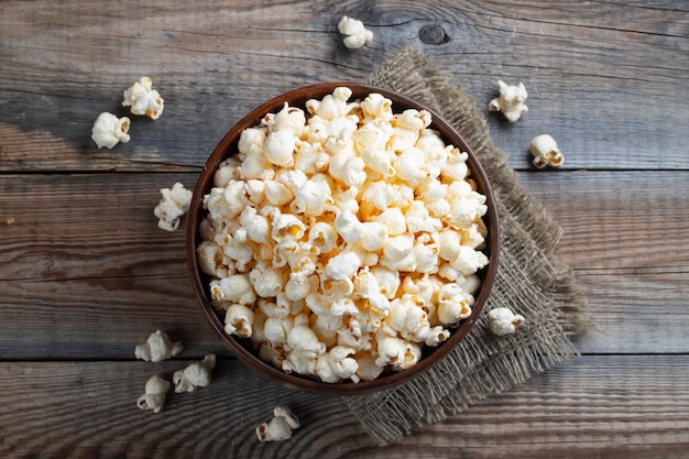 A wooden bowl of salted popcorn.