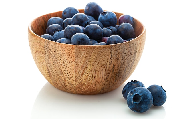 Wooden bowl with blueberry isolated on white background