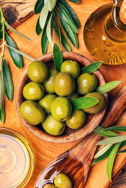 Wooden bowl with green olives