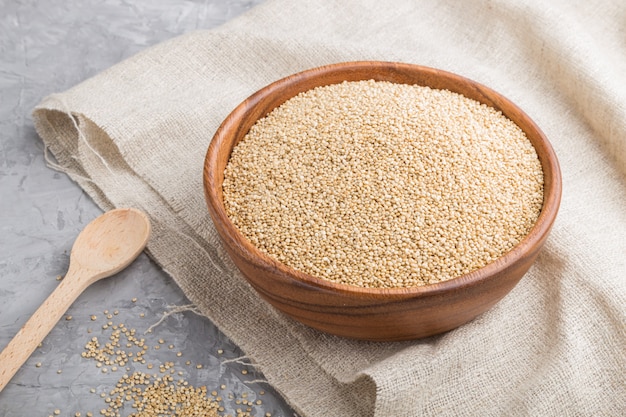 Wooden bowl with raw white quinoa seeds