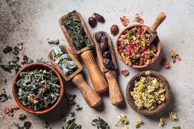 Wooden bowls with medicinal herbs mint raspberry quince chamomile and rose