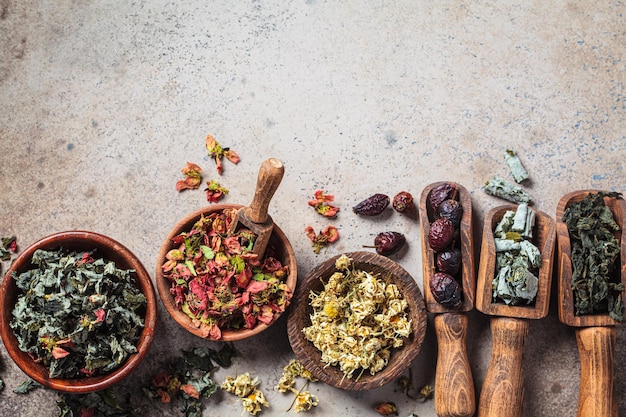 Wooden bowls with medicinal herbs mint raspberry quince chamomile and rose