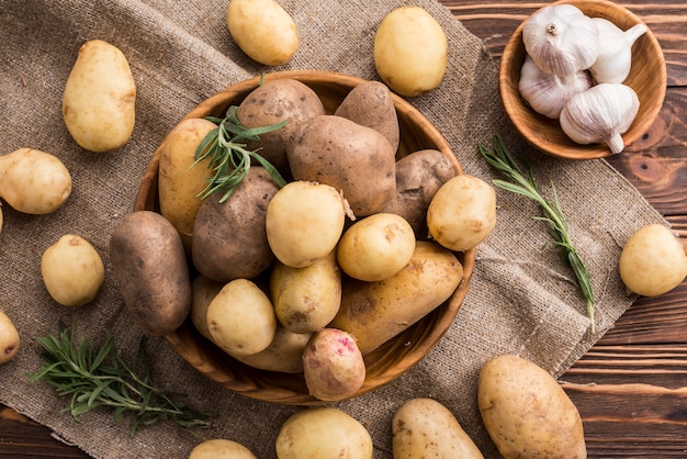 Wooden bowls with potatoes and garlic