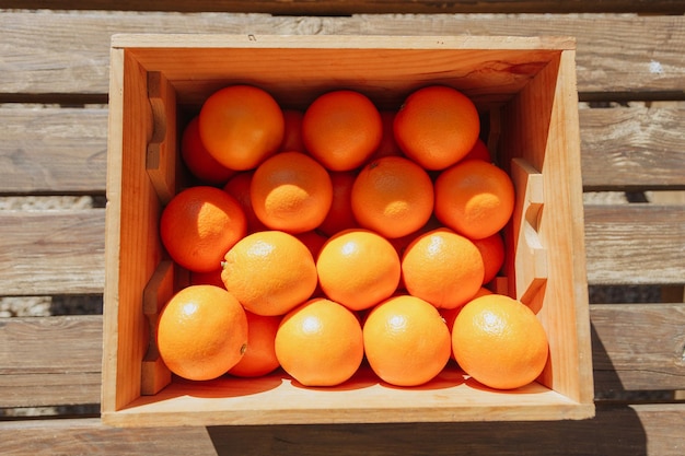 A wooden box of oranges is filled with oranges