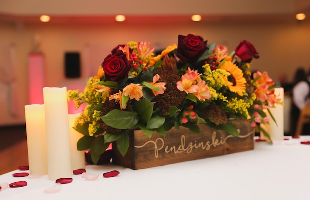 A wooden box with flowers and a candle that says'perils'on it