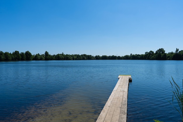 wooden bridge on the lake Summer landscape and blue sky