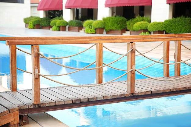 Wooden bridge over swimming pool in luxury hotel