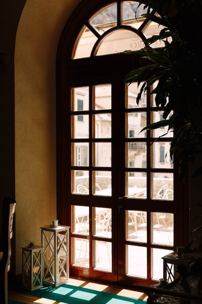 Wooden brown door with glass overlooking the balcony with tables and chairs for relaxation