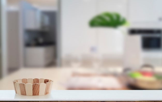 Wooden bucket on white table with blur image of modern kitchen