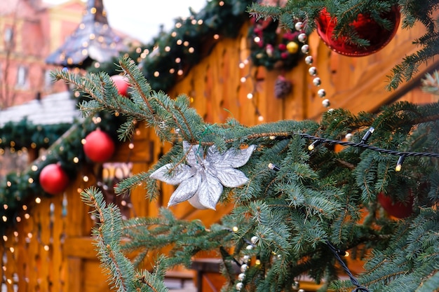 Wooden Building Decorated of Artificial Fir Tree with Lighting Garland and many Red Christmas Balls