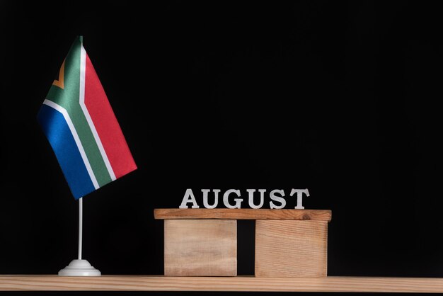 Wooden calendar of August with RSA flag on black background Dates of South Africa in August